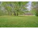 Large backyard with lush lawn, mature trees and a view of the brick home at 2449 Fraser Rd, Marietta, GA 30066