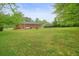 Expansive backyard features green lawn, mature trees and patio seating at 2449 Fraser Rd, Marietta, GA 30066