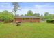 View of the backyard with patio, outdoor seating, brick house and grass at 2449 Fraser Rd, Marietta, GA 30066