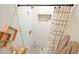 Bright tiled shower with window nook, decorative shelving, and neutral shower curtain at 2449 Fraser Rd, Marietta, GA 30066