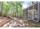 Backyard featuring a stone patio, screened porch, and lush greenery, perfect for outdoor living and enjoying nature at 330 Spring Lake Ter, Roswell, GA 30076