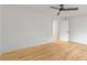 Bright bedroom features pristine white walls, blonde hardwood floors, and modern ceiling fan at 330 Spring Lake Ter, Roswell, GA 30076