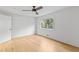 Sunlit bedroom boasts a ceiling fan, a bright window, and blonde hardwood floors at 330 Spring Lake Ter, Roswell, GA 30076