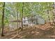 Two-story home exterior with a screened porch and covered porch, surrounded by mature trees, providing a serene backdrop at 330 Spring Lake Ter, Roswell, GA 30076