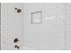 Close up of white subway tile shower with dark bronze fixtures and built in shelving at 330 Spring Lake Ter, Roswell, GA 30076
