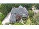 Stunning aerial view of a gray home with a well-manicured lawn and driveway lined with tall trees at 3915 Merriweather Woods, Johns Creek, GA 30022