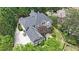 Stunning aerial view of home surrounded by lush landscaping, mature trees, and a long private driveway at 3915 Merriweather Woods, Johns Creek, GA 30022