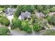 Sweeping aerial shot showcases the beautiful property nestled amongst mature trees, with winding roads nearby at 3915 Merriweather Woods, Johns Creek, GA 30022