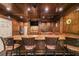 Custom-built wet bar featuring wood cabinetry, barstool seating, and beverage storage at 3915 Merriweather Woods, Johns Creek, GA 30022