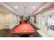 Basement space features a red billiards table, fireplace, and access to the outdoors through french doors at 3915 Merriweather Woods, Johns Creek, GA 30022