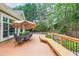 Inviting deck area featuring a dining set, built-in bench, and lush landscaping, perfect for outdoor gatherings and relaxation at 3915 Merriweather Woods, Johns Creek, GA 30022