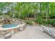 A luxurious pool and hot tub area with stone accents and lush landscaping, creating a serene and private outdoor oasis at 3915 Merriweather Woods, Johns Creek, GA 30022
