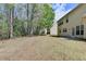 Spacious backyard featuring green grass, mature trees, and a view of the home's rear exterior at 580 Hammersmith Dr, Suwanee, GA 30024
