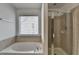 A bathroom showcases a separate tub and glass-enclosed shower at 580 Hammersmith Dr, Suwanee, GA 30024