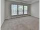 Large bedroom with natural light from three windows and neutral colored carpet floors at 580 Hammersmith Dr, Suwanee, GA 30024