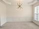 Bright dining room with modern chandelier, chair rail, and neutral carpet at 580 Hammersmith Dr, Suwanee, GA 30024