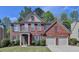 Charming two-story red brick home with a well-maintained lawn, two-car garage and neutral trim at 580 Hammersmith Dr, Suwanee, GA 30024