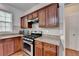 Close up of kitchen featuring granite counters, gas range, vent hood and lots of cabinet space at 580 Hammersmith Dr, Suwanee, GA 30024