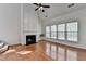 Bright living room with vaulted ceiling, fireplace, hardwood floors, and three large windows at 580 Hammersmith Dr, Suwanee, GA 30024