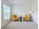 Bright living room with two chairs, small round wood table and a floor lamp with a window view at 580 Hammersmith Dr, Suwanee, GA 30024