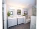 Modern bathroom featuring dual vanities, a soaking tub, and gray tile flooring at 909 Otter Ne Way, Marietta, GA 30068