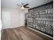 A spacious bedroom featuring wood laminate floors and an accent wall with inspirational words at 909 Otter Ne Way, Marietta, GA 30068