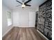 Bright, airy bedroom with contemporary ceiling fan, wood-look floors, and bold, motivational art on the accent wall at 909 Otter Ne Way, Marietta, GA 30068