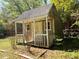Outdoor storage shed with a double door, porch, and siding that needs a little TLC at 2470 Woodmere Dr, Marietta, GA 30068