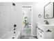 Stylish bathroom featuring tub, subway tile shower, sliding barn door vanity, and matte black fixtures at 754 Fayetteville Se Rd, Atlanta, GA 30316
