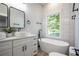Stylish bathroom with a modern vanity, soaking tub, and a bright window with natural light at 754 Fayetteville Se Rd, Atlanta, GA 30316