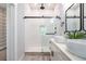 A modern bathroom with dual sinks, glass-enclosed shower, and elegant fixtures and lighting at 754 Fayetteville Se Rd, Atlanta, GA 30316