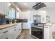 Kitchen features white cabinets, wooden countertop, stainless steel appliances, and black backsplash at 754 Fayetteville Se Rd, Atlanta, GA 30316