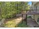 Exterior view of a wooden deck overlooking the spacious backyard with a privacy fence and mature trees at 818 Prada Ct, Lawrenceville, GA 30043