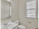 Neutral half bath featuring a single sink vanity, toilet and window with modern fixtures at 818 Prada Ct, Lawrenceville, GA 30043