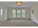 Bright bedroom featuring neutral carpet, a large window and a decorative light fixture at 818 Prada Ct, Lawrenceville, GA 30043