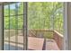 View from inside home, sliding glass doors lead to wooden deck with lush greenery at 818 Prada Ct, Lawrenceville, GA 30043