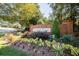 Community entrance sign with brick columns surrounded by lush greenery and flowers at 818 Prada Ct, Lawrenceville, GA 30043