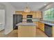 Well-lit kitchen features an island, wood cabinets, stainless steel appliances, and a large window at 818 Prada Ct, Lawrenceville, GA 30043