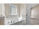 Large soaking tub with tile surround and modern fixtures in a bright bathroom at 121 Dunleith Sw Pkwy, Marietta, GA 30008