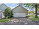 View of the two-car garage door with exterior light and driveway surrounded by small landscaped area at 121 Dunleith Sw Pkwy, Marietta, GA 30008