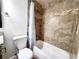 Tiled bathroom with a shower-tub combo and modern fixtures at 645 Crossbridge Aly, Johns Creek, GA 30022