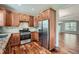 Well-lit kitchen showcasing wooden cabinets, granite countertops, stainless steel appliances, and elegant hardwood floors at 3765 Clear Lake Nw Way, Acworth, GA 30101