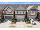 Aerial view of townhomes with brick and siding exteriors, garages, and well-maintained landscaping at 8335 Village Pl, Suwanee, GA 30024