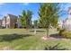 Backyard featuring a grassy lawn, young trees, shrubs, and a view of the neighborhood at 8335 Village Pl, Suwanee, GA 30024