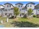 Backyard featuring grass, young trees, shrubs, and a view of the back of the townhomes with a fence on each side at 8335 Village Pl, Suwanee, GA 30024