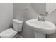 Cozy powder room featuring a pedestal sink and oval mirror at 8335 Village Pl, Suwanee, GA 30024