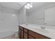 Bathroom featuring a double sink vanity with dark wood cabinets, a shower and a toilet at 8335 Village Pl, Suwanee, GA 30024