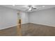 Spacious, empty bedroom with hardwood floors, a ceiling fan, and an attached bathroom view at 8335 Village Pl, Suwanee, GA 30024
