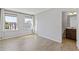 Light-filled bedroom featuring laminate wood floors, windows, and ensuite bathroom at 8335 Village Pl, Suwanee, GA 30024