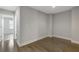 Bright, empty bedroom featuring hardwood floors and ample natural light through an open doorway at 8335 Village Pl, Suwanee, GA 30024